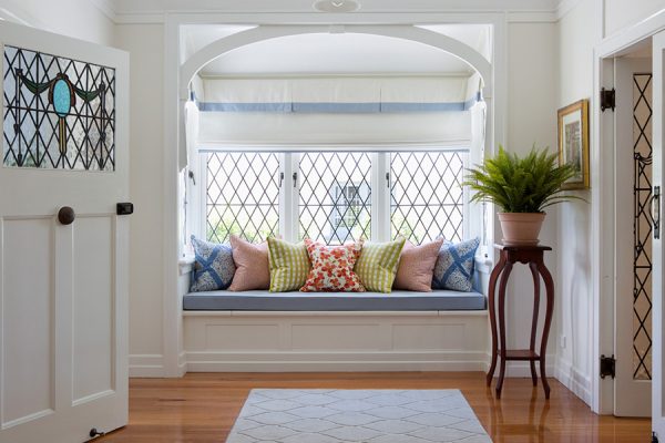an organized and fresh window seat with throw pillows on it