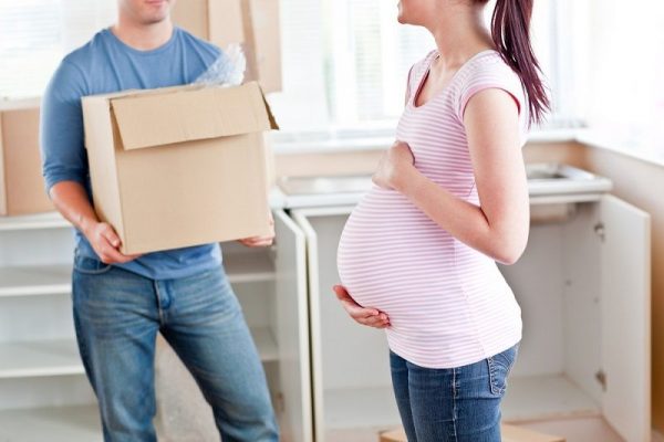 a pregnant couple packing for a move