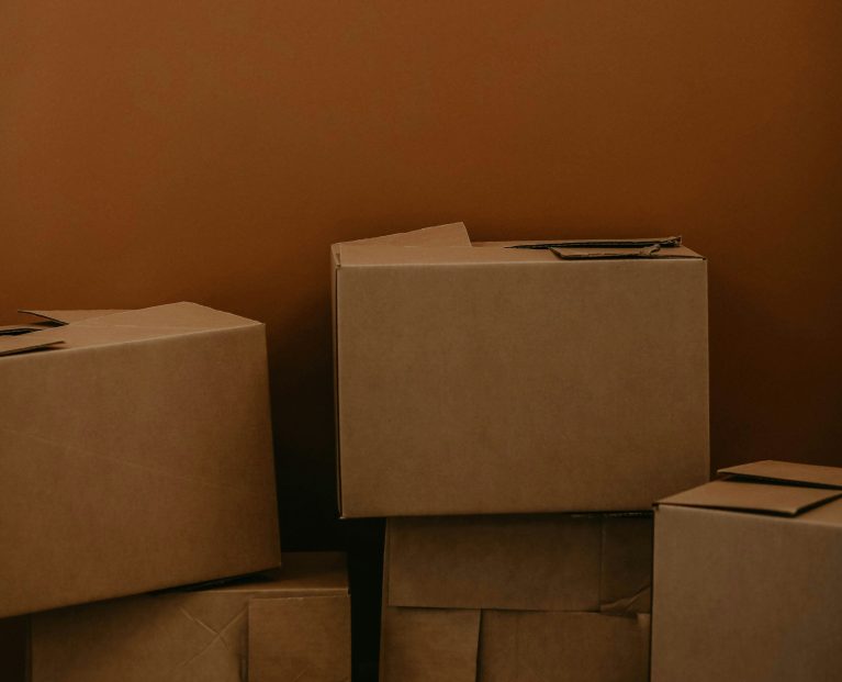 stack of boxes against a brown wall